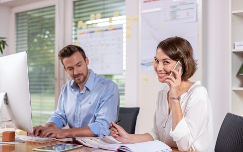 Male and female project manager collaborating in front of computer screen at office