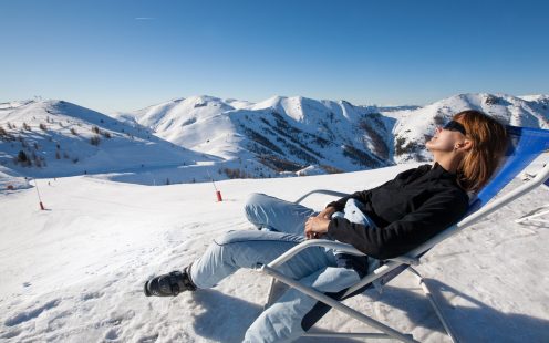 woman sunbathing in the snow in a deckchair